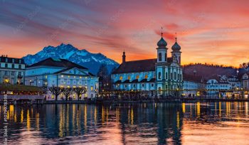 Splended sunset over the  Lucerne Jesuit church with Pilatus mountain at background in the evening and Rathaussteg in Christmas illumination, Switzerland